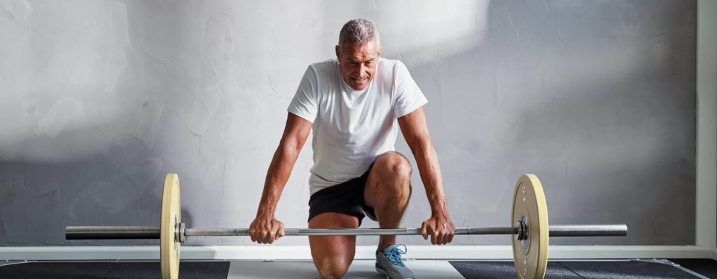 Mature man with weights at gym